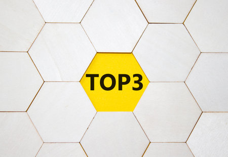 Top 3 symbol. Concept word Top 3 on wooden comb puzzle. Beautiful yellow background. Business and...