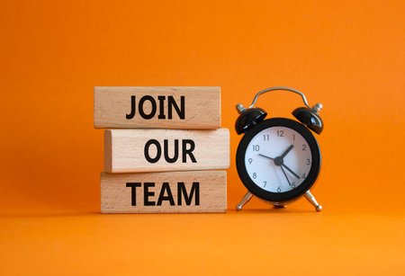 Join our team symbol. Wooden blocks with words Join our team. Beautiful orange background with alarm clock. Business and Join our team concept. Copy space.の写真素材