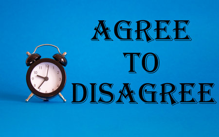 Agree to Disagree symbol. Beautiful blue background with alarm clock. Business and Agree to Disagree concept. Copy space.の写真素材