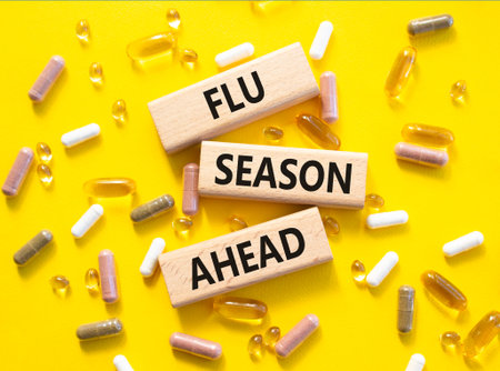 Flu Season Ahead symbol. Concept word Flu Season Ahead on wooden blocks. Beautiful yellow background with pills. Medicine and Flu Season Ahead concept. Copy spaceの写真素材