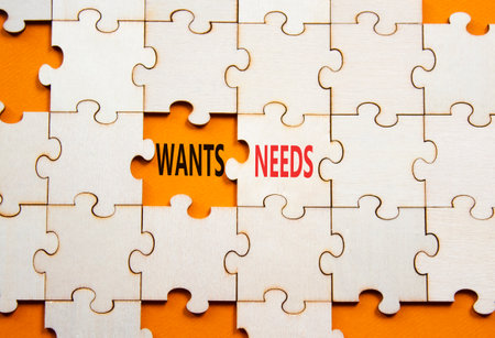Wants and Needs symbol. Concept word Wants and Needs on wooden blocks. Beautiful orange background. Business and Wants and Needs concept. Copy spaceの写真素材