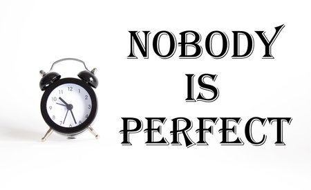 Nobody is Perfect symbol. Concept word Nobody is Perfect on Beautiful white background with alarm clock. Business and Nobody is Perfect concept. Copy spaceの写真素材