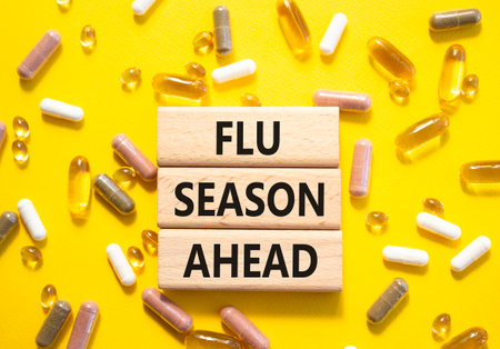 Flu Season Ahead symbol. Concept word Flu Season Ahead on wooden blocks. Beautiful yellow background with pills. Medicine and Flu Season Ahead concept. Copy spaceの写真素材