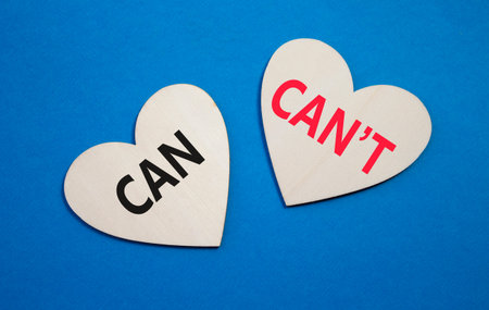 Can or Cant symbol. Concept word Can or Cant on wooden hearts. Beautiful blue background. Business...