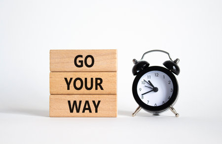 Go Your Way symbol. Wooden blocks with words Go Your Way. Beautiful white background with alarm clock. Business and Go Your Way concept. Copy space.の写真素材