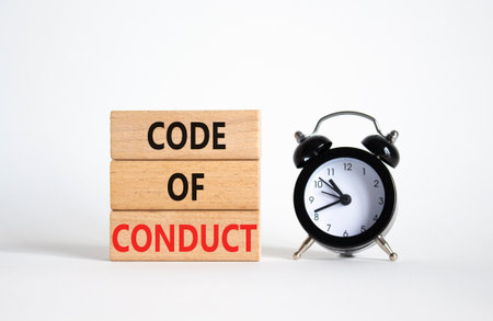 Code of conduct symbol. Wooden blocks with words Code of conduct with alarm clock. Beautiful white background. Business and Code of conduct concept. Copy space.の写真素材