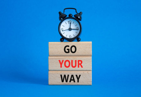Go Your Way symbol. Wooden blocks with words Go Your Way. Beautiful blue background with alarm...