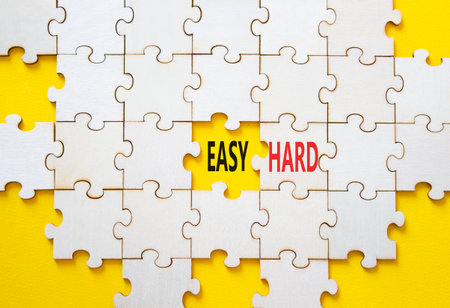 Easy or Hard symbol. Concept word Easy or Hard on wooden puzzle. Beautiful yellow background. Business and Easy or Hard concept. Copy spaceの写真素材