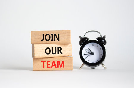 Join our team symbol. Wooden blocks with words Join our team. Beautiful white background with alarm clock. Business and Join our team concept. Copy space.の写真素材