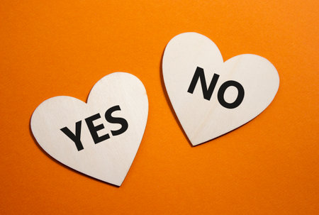 Yes or No symbol. Concept word Yes or No on wooden hearts. Beautiful orange background. Business and Yes or No concept. Copy spaceの写真素材