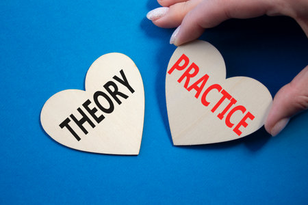 Theory or practice symbol. Concept word Theory or Practice on wooden hearts. Businessman hand. Beautiful blue background. Business and Theory or Practice concept. Copy spaceの写真素材