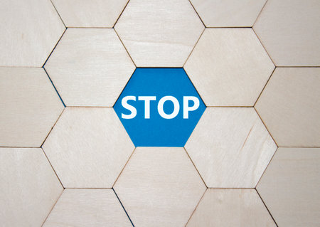 Stop symbol. Concept word Stop on wooden comb puzzle. Beautiful blue background. Business and Stop concept. Copy space.の写真素材