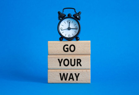 Go Your Way symbol. Wooden blocks with words Go Your Way. Beautiful blue background with alarm...