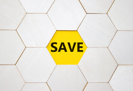 Save symbol. Concept word Save on wooden comb puzzle. Beautiful yellow background. Business and Save...