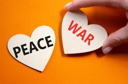 War or Peace symbol. Concept word War or Peace on wooden hearts. Businessman hand. Beautiful orange...