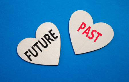 Future or Past symbol. Concept word Future or Past on wooden hearts. Beautiful blue background. Business and Future or Past concept. Copy spaceの写真素材