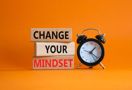 Change your mindset symbol. Concept words Change your mindset on wooden blocks with alarm clock. Beautiful orange background. Business and Change your mindset concept. Copy space.の写真素材