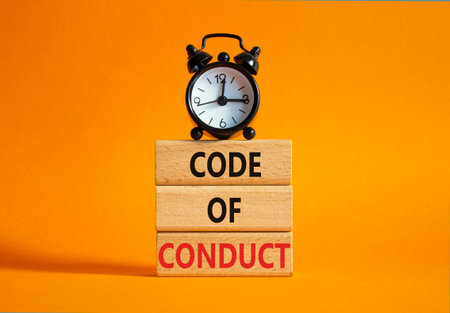 Code of conduct symbol. Wooden blocks with words Code of conduct with alarm clock. Beautiful orange background. Business and Code of conduct concept. Copy space.の写真素材
