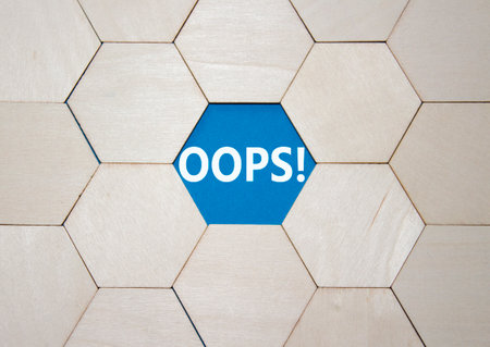 Oops symbol. Concept word Oops on wooden comb puzzle. Beautiful blue background. Business and Oops concept. Copy space.の写真素材