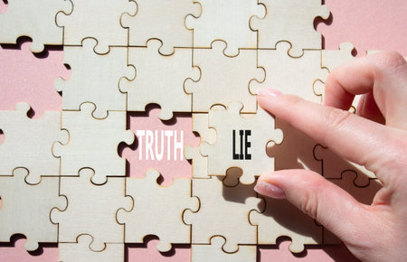 Truth or Lie symbol. Concept word Truth or Lie on wooden puzzle. Businessman hand. Beautiful pink background. Business and Truth or Lie concept. Copy spaceの写真素材
