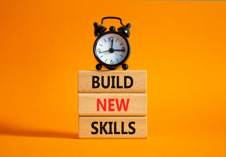 Build New skills symbol. Concept word Build New skills on wooden blocks with alarm clock. Beautiful orange background. Business and Build New skills concept. Copy spaceの写真素材