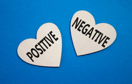 Positive or Negative symbol. Concept word Positive or Negative on wooden hearts. Beautiful blue background. Business and Positive or Negative concept. Copy spaceの写真素材