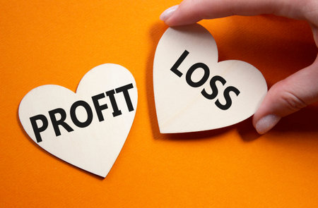 Profit or Loss symbol. Concept word Profit or Loss on wooden hearts. Businessman hand. Beautiful...