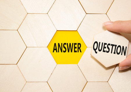 Answer or Question symbol. Concept word Answer or Question on wooden comb puzzle. Beautiful yellow...