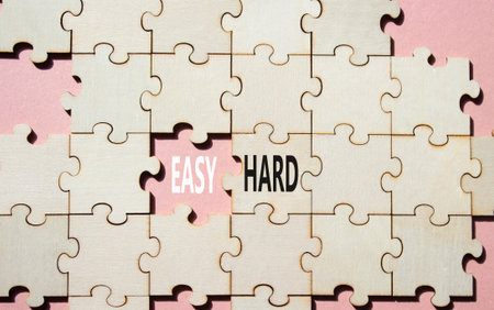 Easy or Hard symbol. Concept word Easy or Hard on wooden puzzle. Beautiful pink background. Business and Easy or Hard concept. Copy spaceの写真素材