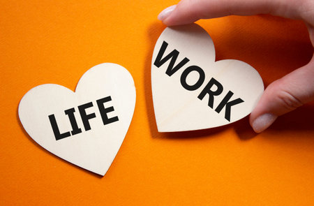 Life or Work symbol. Concept word Life or Work on wooden hearts. Businessman hand. Beautiful orange...