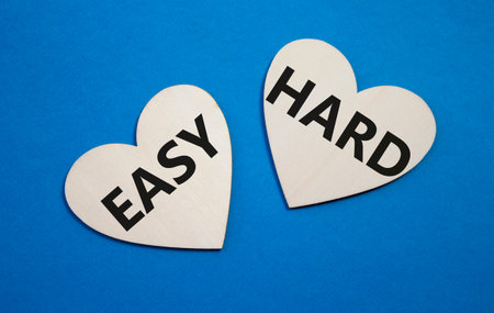 Easy or Hard symbol. Concept word Easy or Hard on wooden hearts. Beautiful blue background. Business and Easy or Hard concept. Copy spaceの写真素材
