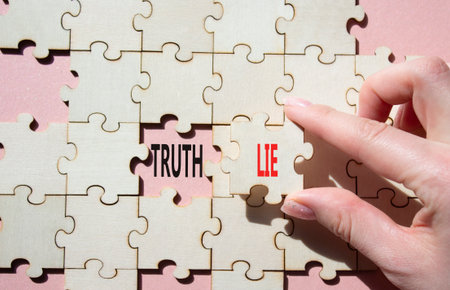 Truth or Lie symbol. Concept word Truth or Lie on wooden puzzle. Businessman hand. Beautiful pink background. Business and Truth or Lie concept. Copy spaceの写真素材