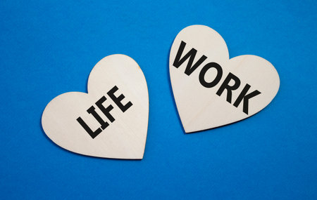 Life or Work symbol. Concept word Life or Work on wooden hearts. Beautiful blue background. Business...
