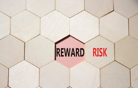 Risk or Reward symbol. Concept word Risk or Reward on wooden comb puzzle. Beautiful pink background....