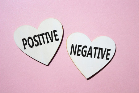 Positive or Negative symbol. Concept word Positive or Negative on wooden hearts. Beautiful pink...