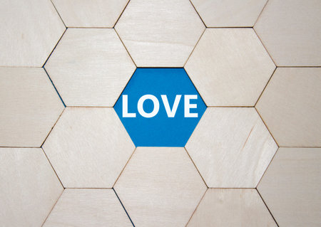 Love symbol. Concept word Love on wooden comb puzzle. Beautiful blue background. Business and Love...