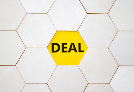 Deal symbol. Concept word Deal on wooden comb puzzle. Beautiful yellow background. Business and Deal concept. Copy space.の写真素材