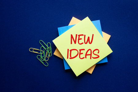 New ideas symbol. Yellow sticky note with concept words New Ideas. Beautiful deep blue background....