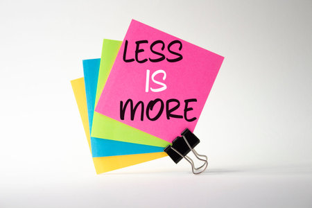 Less is More symbol. Sticky Notes with Concept words Less is More. Beautiful white background....