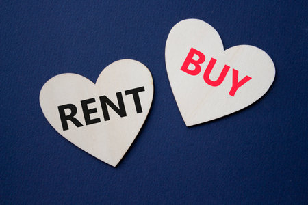 Rent or Buy symbol. Concept word Rent or Buy on wooden hearts. Beautiful deep blue background. Business and Rent or Buy concept. Copy spaceの写真素材
