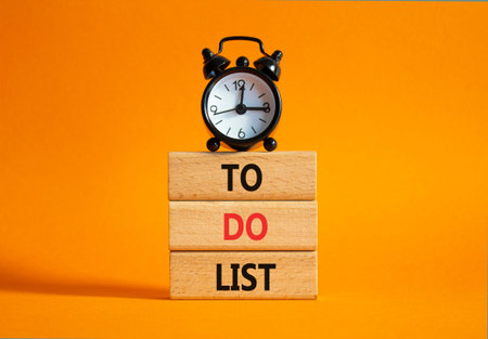 To Do List symbol. Concept words To Do List on wooden blocks. Beautiful orange background with alarm...