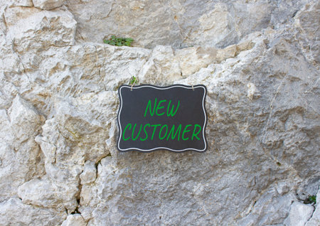 New Customer symbol. Stone wall with words New Customer. Beautiful stone background. Business and...