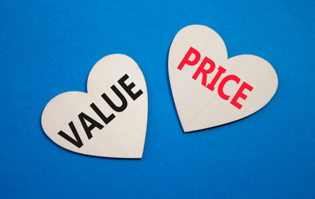 Price and Value symbol. Concept word Price and Value on wooden hearts. Beautiful blue background....