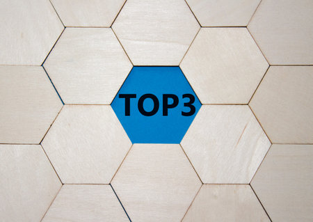 Top 3 symbol. Concept word Top 3 on wooden comb puzzle. Beautiful blue background. Business and Top...