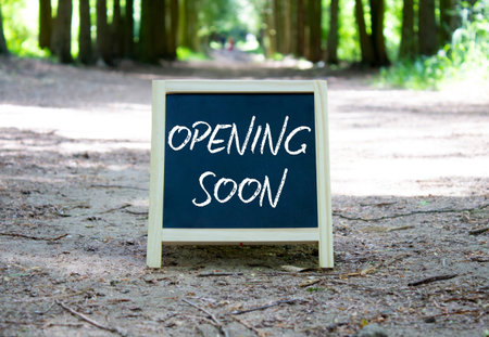 Opening soon symbol. Concept word Opening soon on chalk blackboard. Beautiful forest background....