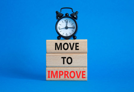 Move to Improve symbol. Concept words Move to Improve on wooden blocks. Beautiful blue background...