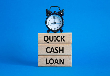 Quick Cash Loan symbol. Concept words Quick Cash Loan on wooden blocks. Beautiful blue background...