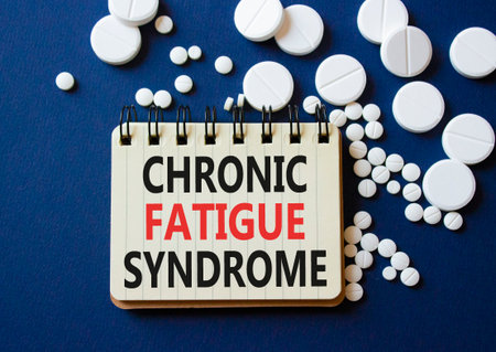 Chronic Fatigue Syndrome symbol. Concept word Chronic Fatigue Syndrome on notebook. Beautiful deep blue background with pills. Medicine and Chronic Fatigue Syndrome concept. Copy spaceの写真素材