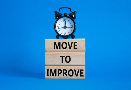 Move to Improve symbol. Concept words Move to Improve on wooden blocks. Beautiful blue background...