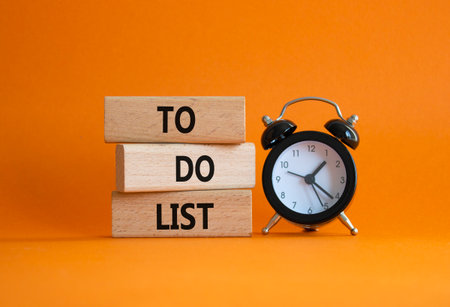 To Do List symbol. Concept words To Do List on wooden blocks. Beautiful orange background with alarm clock. Business and To Do List concept. Copy spaceの写真素材